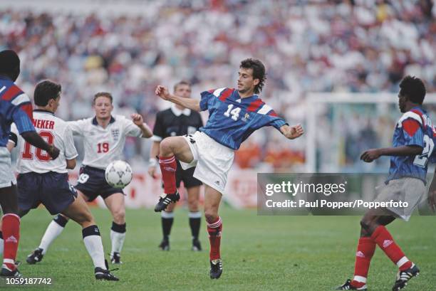 French professional footballer Jean-Philippe Furand, midfielder with Marseille, prepares to clear the ball away from English players Gary Lineker and...