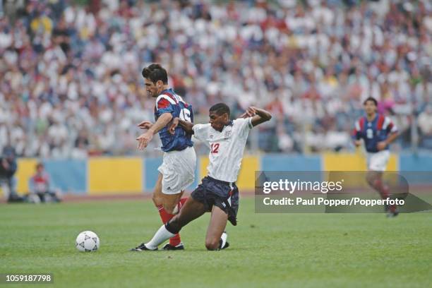 English professional footballer Carlton Palmer , midfielder with Sheffield Wednesday, moves in for a sliding tackle to stop advancing French player...