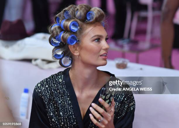 Dutch model Romee Strijd prepares for the 2018 Victoria's Secret Fashion Show in hair and make-up backstage on November 8, 2018 at Pier 94 in New...