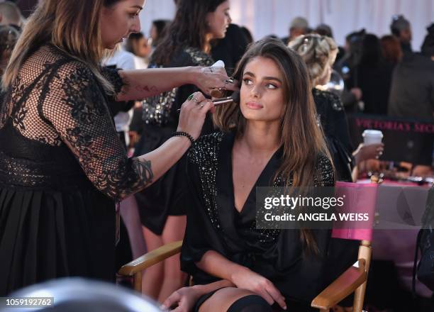 Model Taylor Hill prepares for the 2018 Victoria's Secret Fashion Show in hair and make-up backstage on November 8, 2018 at Pier 94 in New York City....