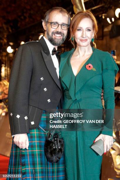British screenplay writer J. K. Rowling poses with her husband Neil Murray for a photograph as they arrive for the premier of the fantasy film...