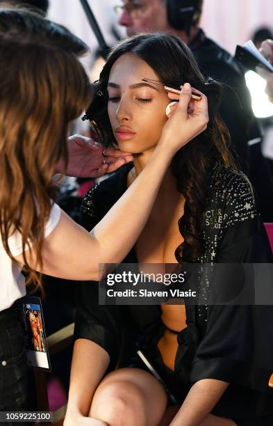 Model Yasmin Wijnaldum prepares backstage for hair and makeup at 2018 Victoria's Secret Fashion Show at Pier 94 on November 8, 2018 in New York City.