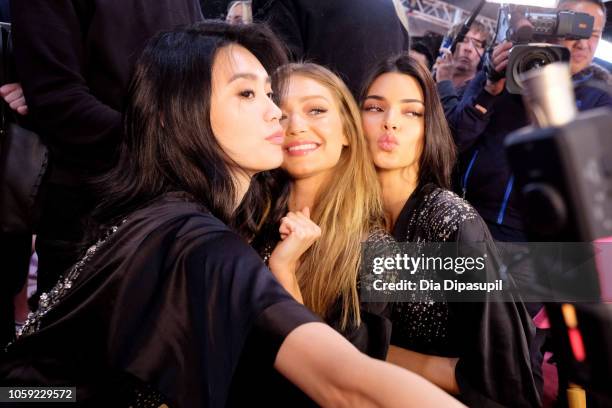 Ming Xi, Gigi Hadid, and Bella Hadid prepare backstage during the 2018 Victoria's Secret Fashion Show in New York at Pier 94 on November 8, 2018 in...