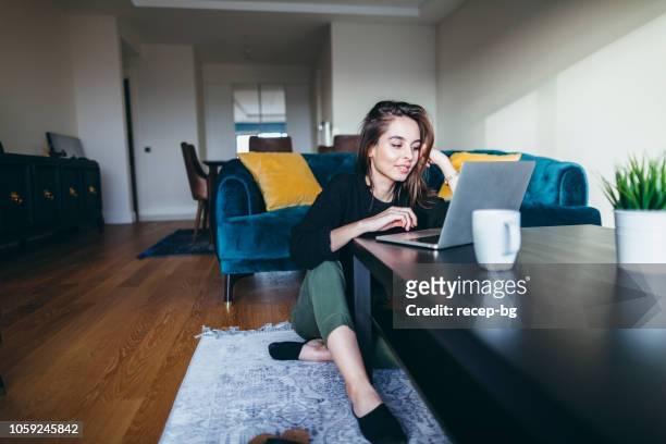 young woman using laptop at home - using laptop at home happy copy space stock pictures, royalty-free photos & images
