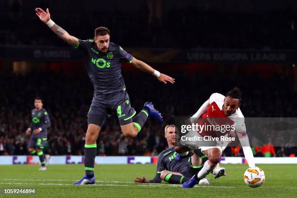 Pierre-Emerick Aubameyang of Arsenal is fouled by Jeremy Mathieu of Sporting CP who is sent off as Sebastian Coates of Sporting CP moves in during...