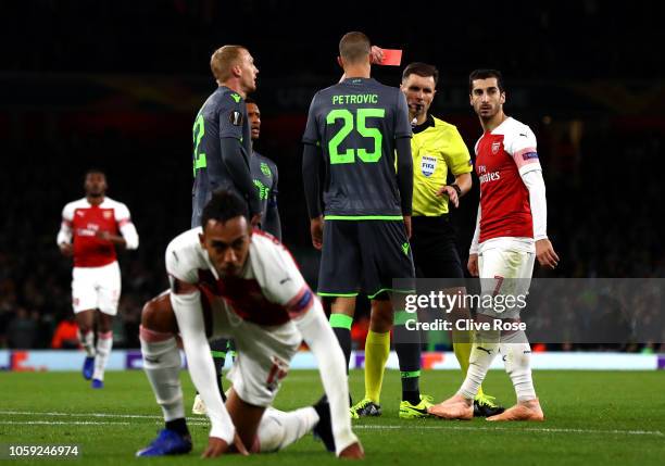 Jeremy Mathieu of Sporting CP is shown a red card by referee Gediminas Mazeika after a foul on Pierre-Emerick Aubameyang of Arsenal during the UEFA...
