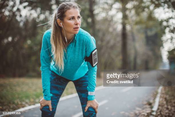 vrouw uitgevoerd in park - runner tired stockfoto's en -beelden