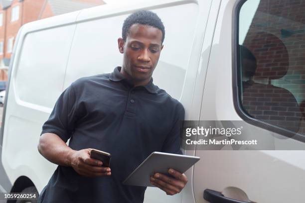 tradesman texting customer delivery time - plumber van stock pictures, royalty-free photos & images