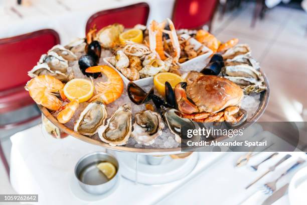 seafood plate with oysters, prawns, crab, mussels served on crushed ice in plate in a luxury restaurant - krabba fisk och skaldjur bildbanksfoton och bilder