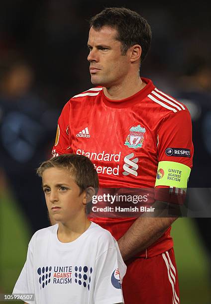 Jamie Carragher of Liverpool and his mascot show their support for the Unite Against Racism campaign ahead of the UEFA Europa League match between...