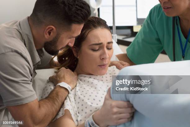 young woman giving birth with her husband supporting her - labor childbirth stock pictures, royalty-free photos & images
