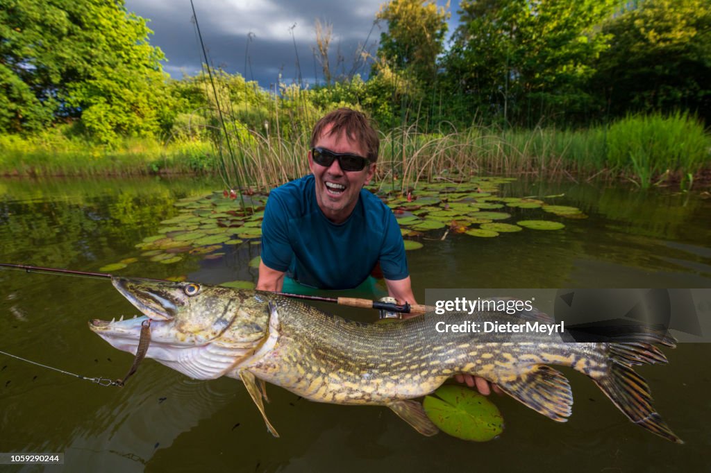 Fisherman holding a pike fish