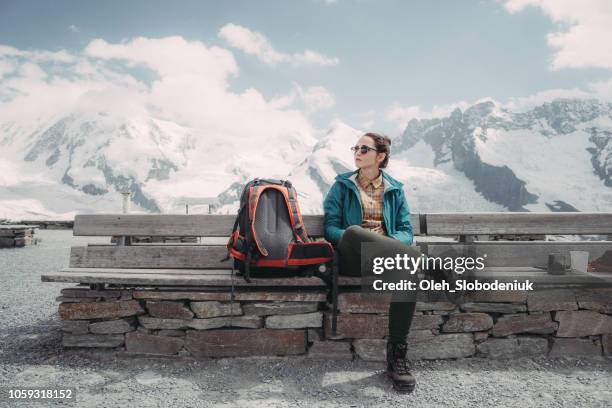 mujer sentada en la banca en el fondo del glaciar en los alpes suizos - alpes peninos fotografías e imágenes de stock