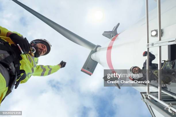 hoge handarbeiders werken op grootste windturbine - grootste stockfoto's en -beelden