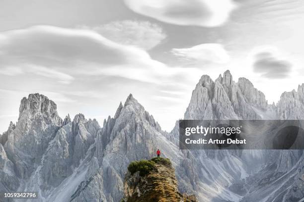 small hiker facing the sharp dolomite mountains in the italian alps. - vertigo stock pictures, royalty-free photos & images