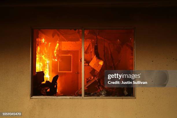 The interior of a building burns as the Camp Fire moves through the area on November 8, 2018 in Paradise, California. Fueled by high winds and low...