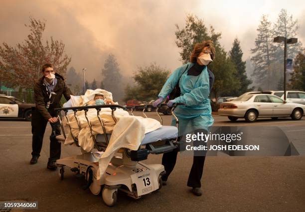Patients are quickly evacuated from the Feather River Hospital as it burns down during the Camp fire in Paradise, California on November 8, 2018. -...