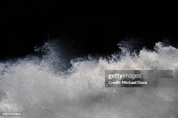 water splashing on black background - river rapids stock pictures, royalty-free photos & images