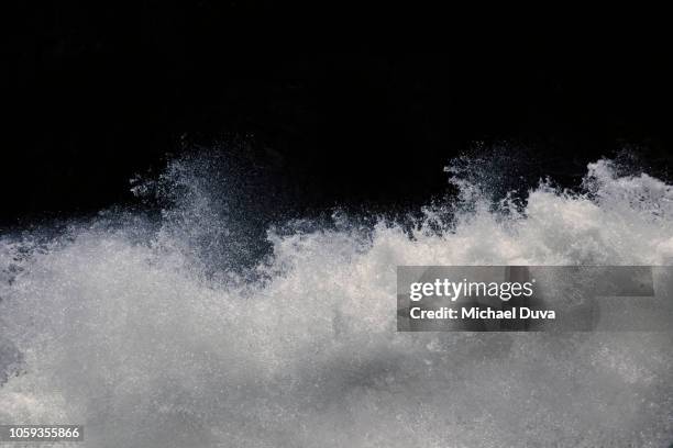 water splashing on black background - borrifo imagens e fotografias de stock