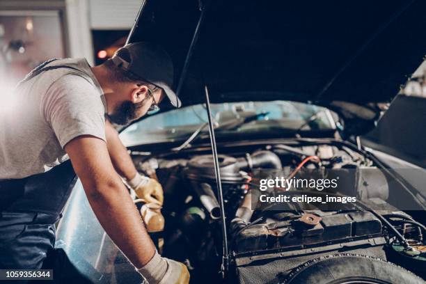 reparatie man die werkt in de garage op reparatie van oude timer - repair garage stockfoto's en -beelden