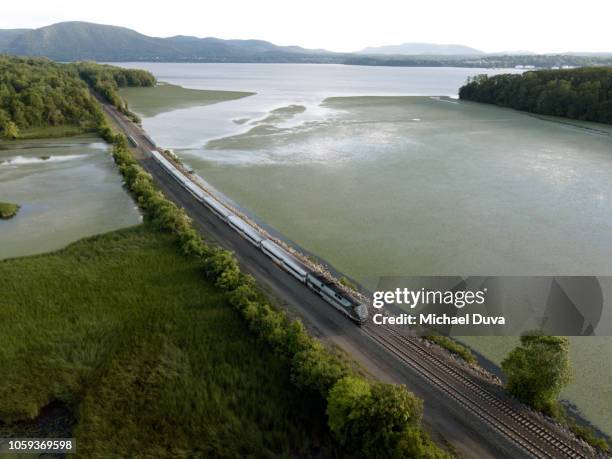 passenger train traveling up the hudson river - spoorwegvervoer stockfoto's en -beelden