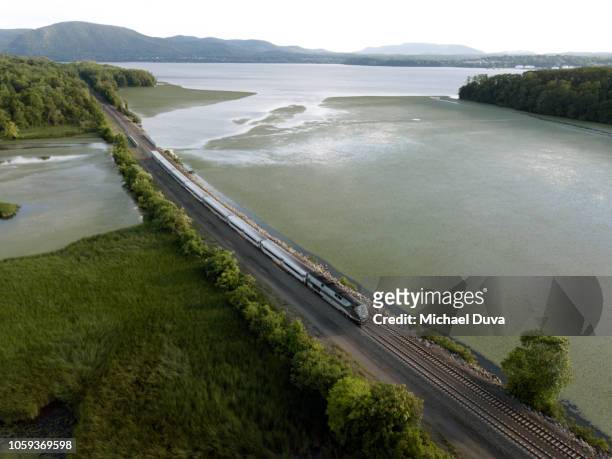 passenger train traveling up the hudson river - aerial train stock pictures, royalty-free photos & images