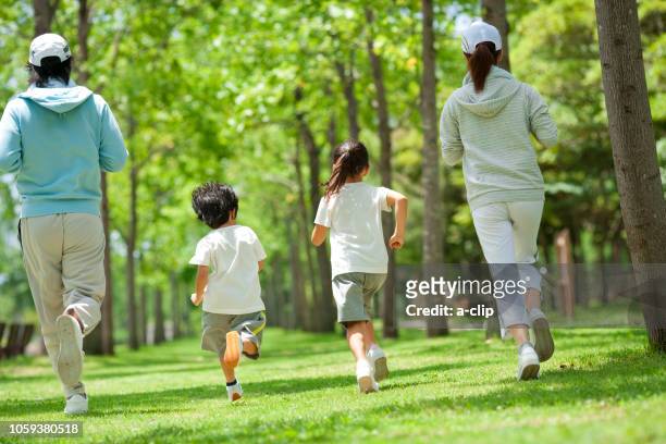 ジョギングする家族の後姿 - 家族　日本人　走る ストックフォトと画像