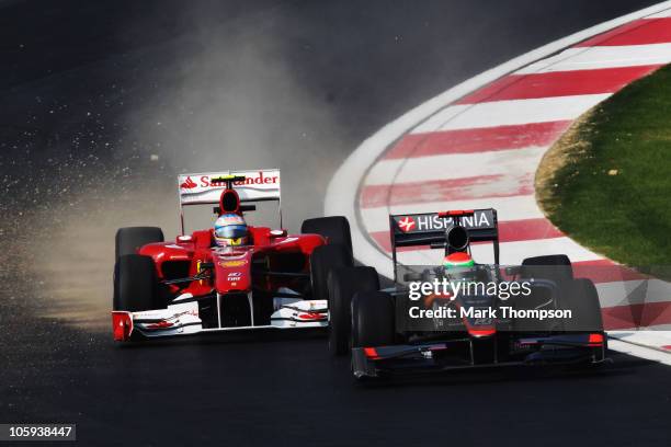 Fernando Alonso of Spain and Ferrari and Sakon Yamamoto of Japan and Hispania Racing Team drive thru the final corner during practice for the Korean...