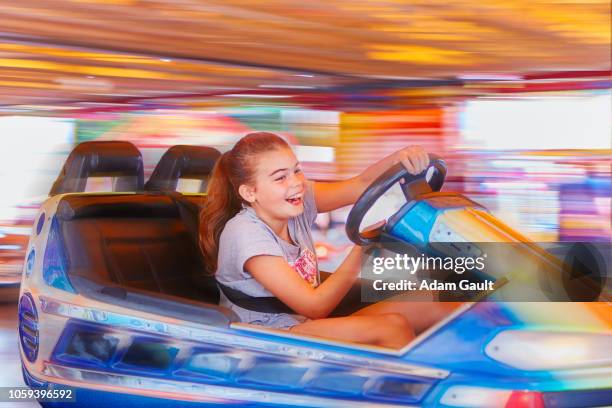 young girl riding bumper cars at fairground - autoscooter stock-fotos und bilder