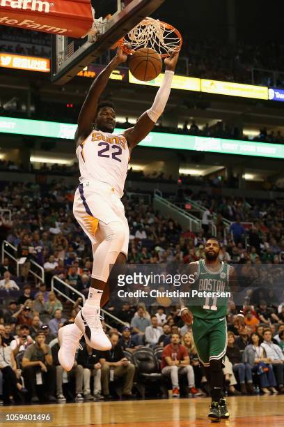 Deandre Ayton of the Phoenix Suns slam dunks the ball past Kyrie Irving of the Boston Celtics during the first half of the NBA game at Talking Stick...