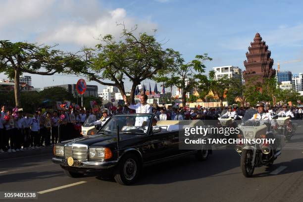 Cambodian Prime Minister Hun Sen greets people from a motorcade during an Independence Day celebration in Phnom Penh on November 9, 2018. - Cambodia...