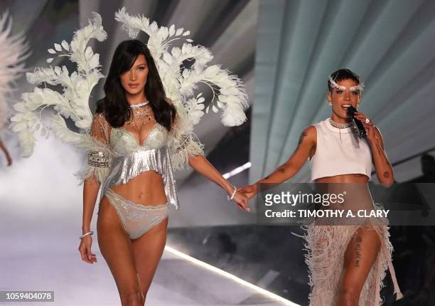 Model Bella Hadid walks the runway past Halsey as she performs at the 2018 Victoria's Secret Fashion Show on November 8, 2018 at Pier 94 in New York...