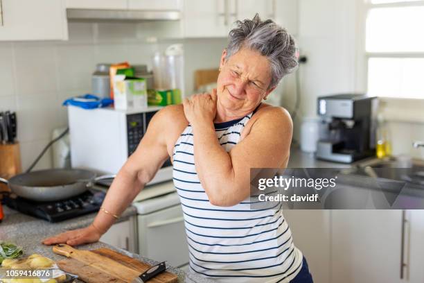 senior woman with shoulder pain - shoulder stock pictures, royalty-free photos & images