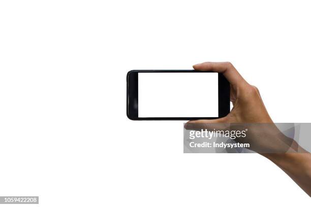 cropped hand holding smart phone against white background - horizontal stock-fotos und bilder
