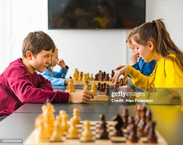 kinderen van verschillende leeftijden, jongens en meisjes, schaken op het toernooi in de schaakclub - alex boys stockfoto's en -beelden
