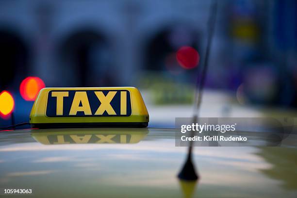 taxi sign and reflections at night - taxiteken stockfoto's en -beelden