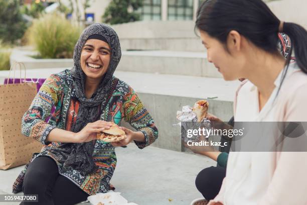 Joven mujer musulmana compras y tener una mordedura a comer con amigos