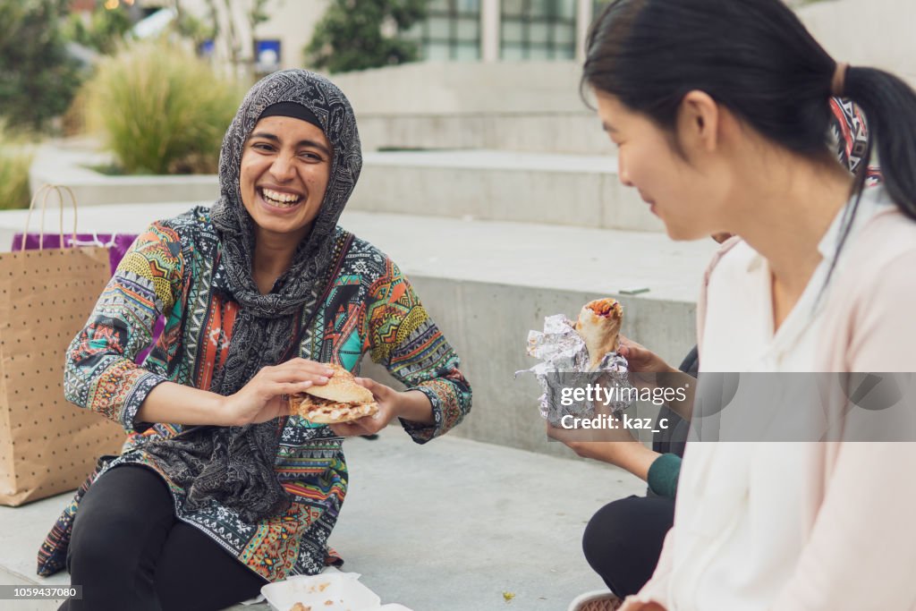 Young muslim woman out shopping and having a bite to eat with friends