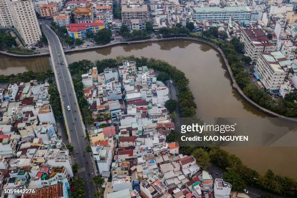 This aerial photo taken on October 19, 2018 shows houses along the Xuyen Tam canal in Ho Chi Minh City. - There are about 20,000 remaining households...