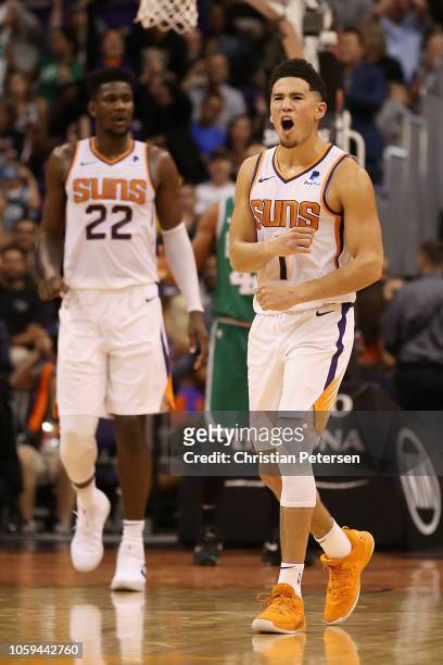 Devin Booker of the Phoenix Suns reacts alongside Deandre Ayton after scoring against the Boston Celtics during the second half of the NBA game at...