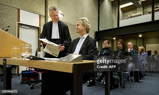Dutch anti-Islam deputy Geert Wilders and his lawyer Bram Moszkowicz look at newspapers in the courtroom in Amsterdam on October 22, 2010 on the...