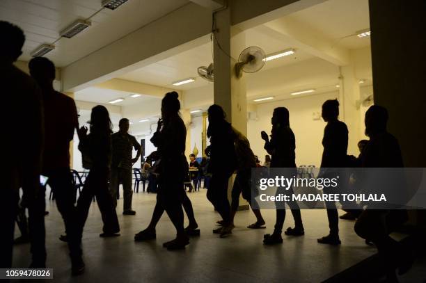 Group of foreign women rounded up by police from karaoke bars in Thailand's southern province of Narathiwat are taken to city hall during a campaign...