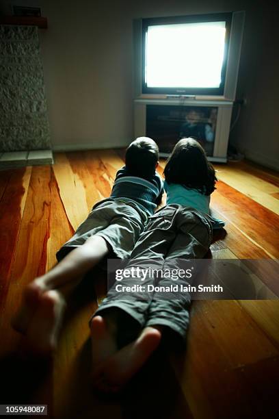 watching tv - boy barefoot rear view stockfoto's en -beelden