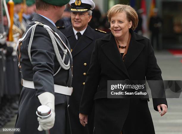 German Chancellor Angela Merkel greets members of a guard of honour in the courtyard of the Chancellery ahead of the arrival of Chilean President...