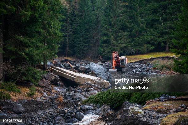 An escavator clearing up a road in disaster-hit of the city of Rocca Pietore, italian Dolomites, Belluno Province, with the Serrai di Sottoguda...