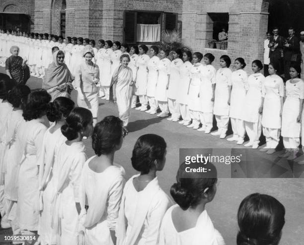 Britain's Queen Elizabeth II walks past students in front of Indian High Commissionner to the United Kingdom, Vijaya Lakshmi Pandit during a visit at...