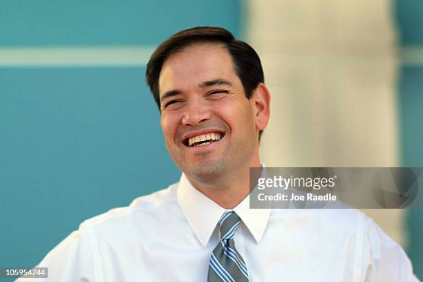 Republican Senate candidate Marco Rubio laughs as he speaks to the media while waiting for his wife Jeanette Rubio to cast her ballot at an early...