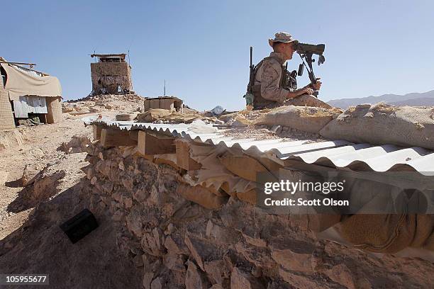 Marine marksman spotter Cpl. Cody Scholes of Belfast, NY with India Battery, 3rd Battalion, 12th Marine Regiment watches for enemy movement as he and...