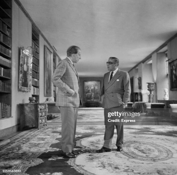 American industrialist and founder of Getty Oil, Jean Paul Getty pictured on left with Greek shipping tycoon Aristotle Onassis in the library at...