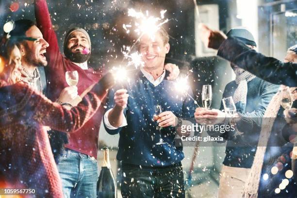 new year's party. - friends with sparkler fireworks stock pictures, royalty-free photos & images